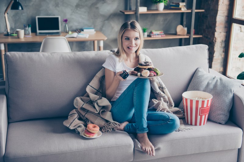 woman streaming tv and eating junk food