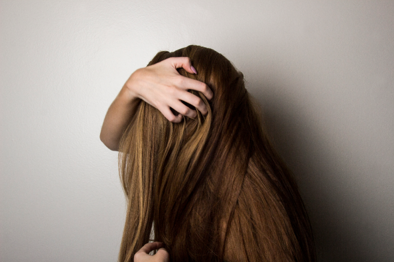 woman touching her long dark hair