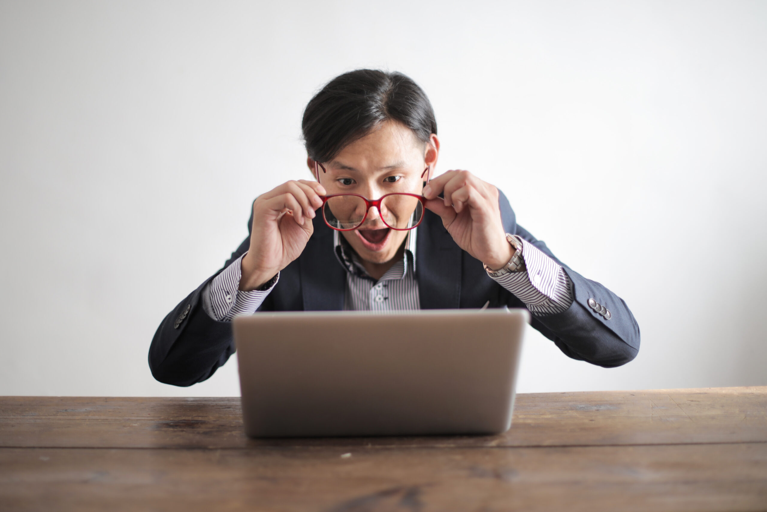 Amazed formal male looking at laptop screen