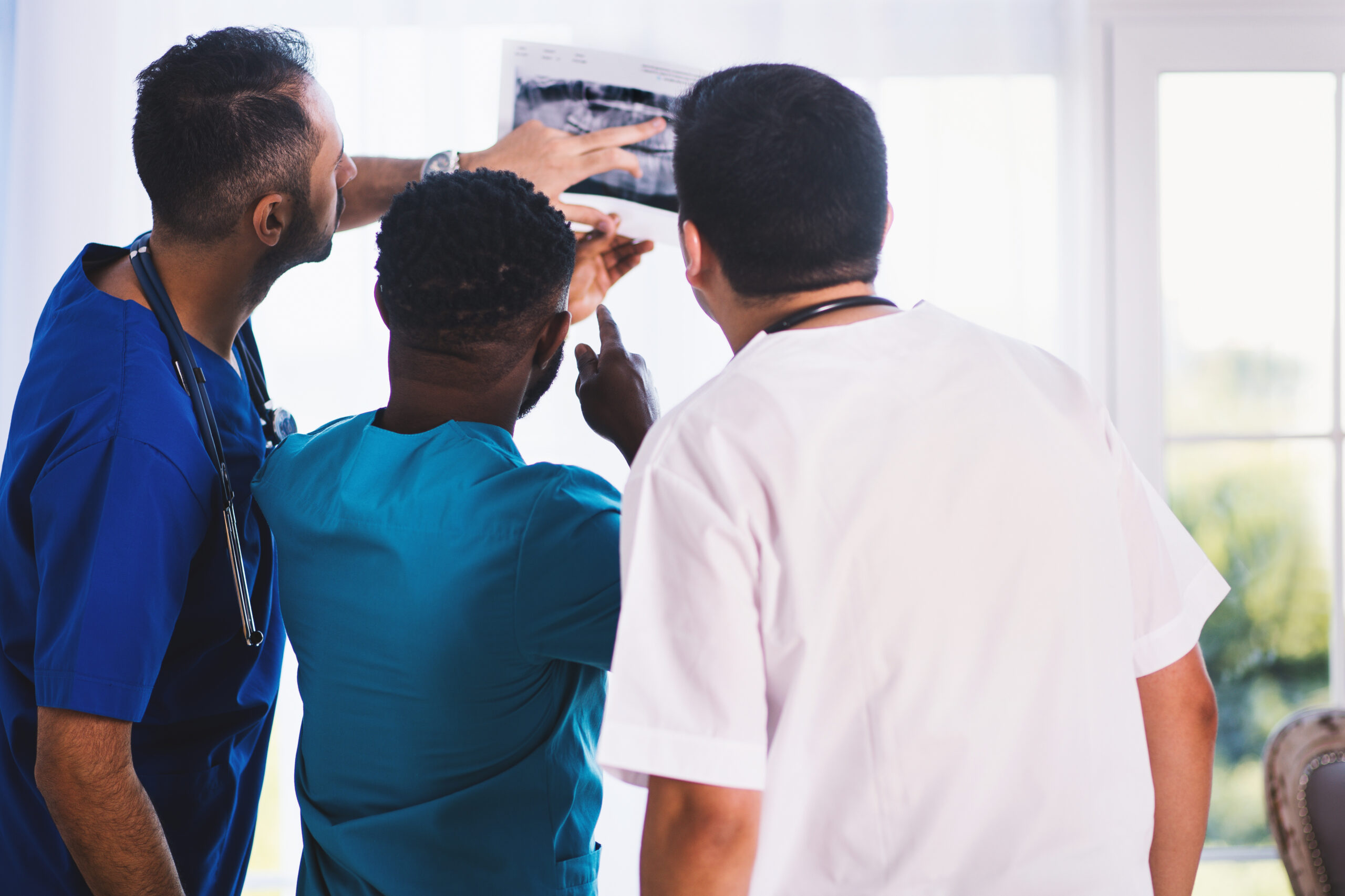 Three person looking at x ray result