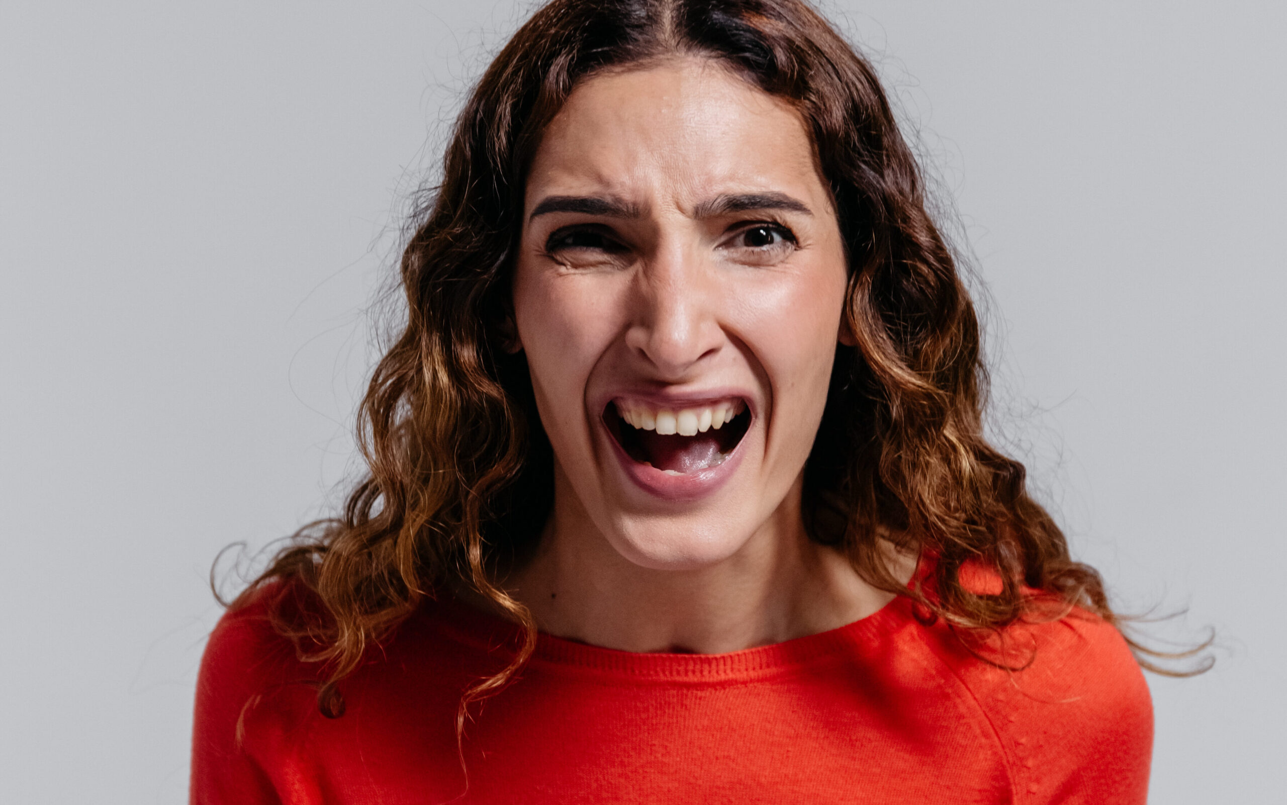 Woman in orange long sleeve shirt feeling irritated