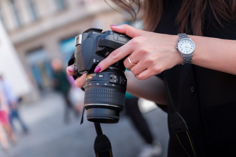 Woman holding black dslr camera