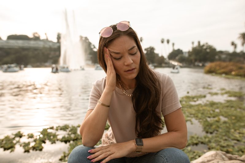 A woman sitting beside a lake