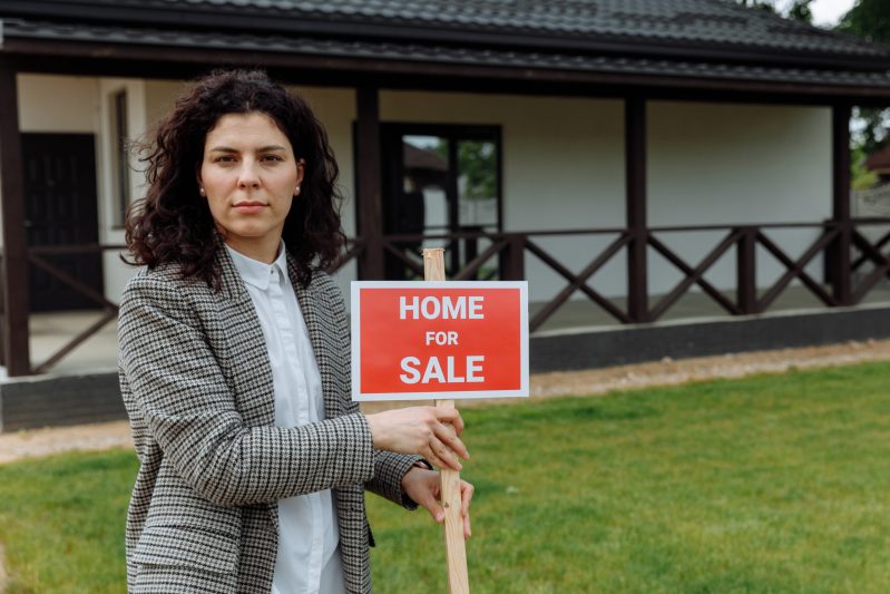 A real estate agent holding a sign