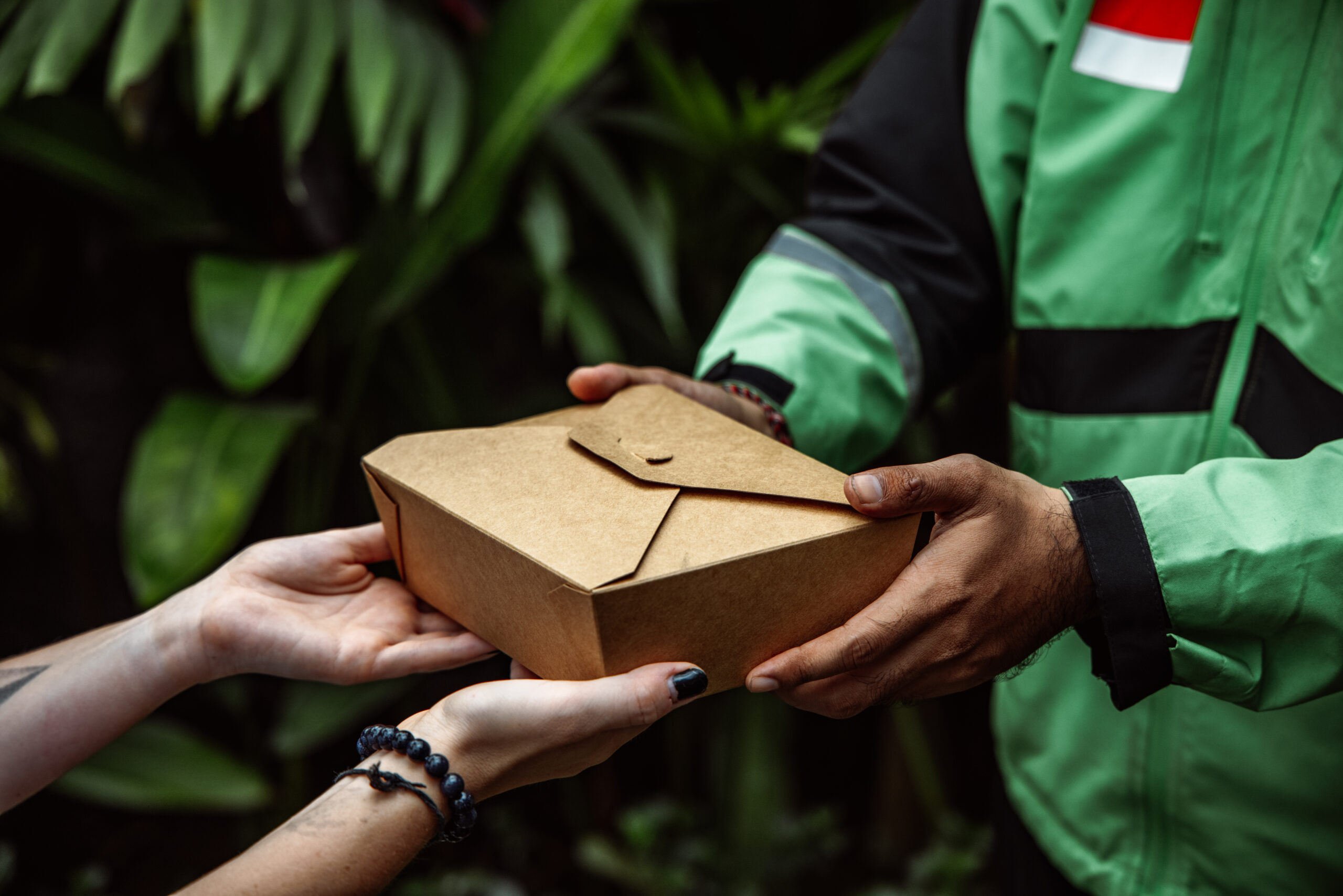 Delivery driver handing takeout box to person