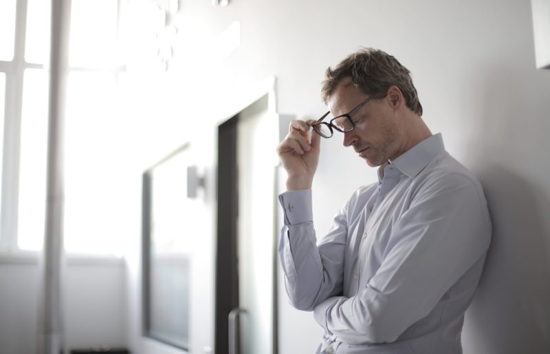 Photo of man holding black eyeglasses