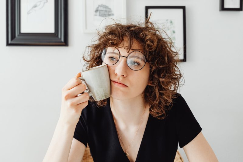 Curly haired woman holding a coffee mug