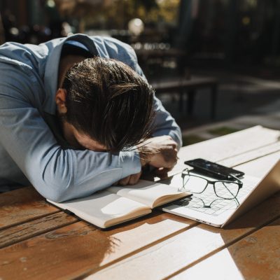 A tired man resting on a wooden table