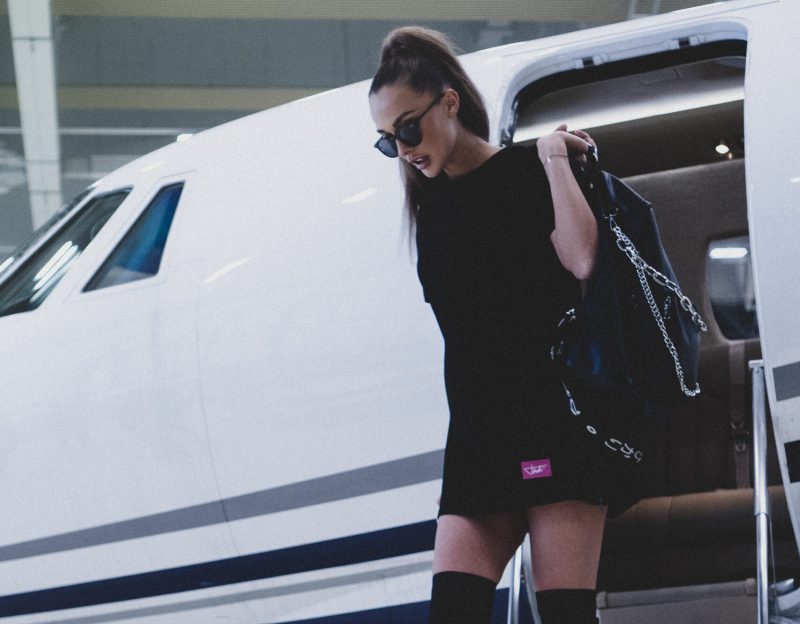 Unknown celebrity wearing black dress carrying black leather bag